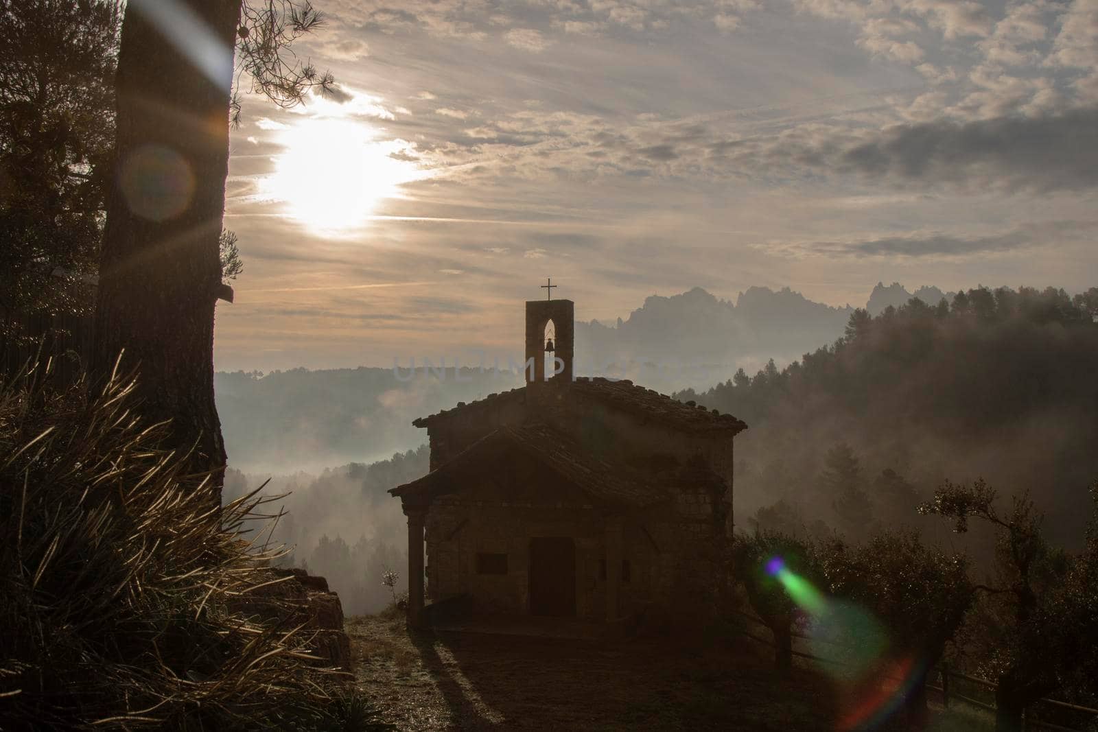 Misty beautiful landscape showing a small church and some mountains