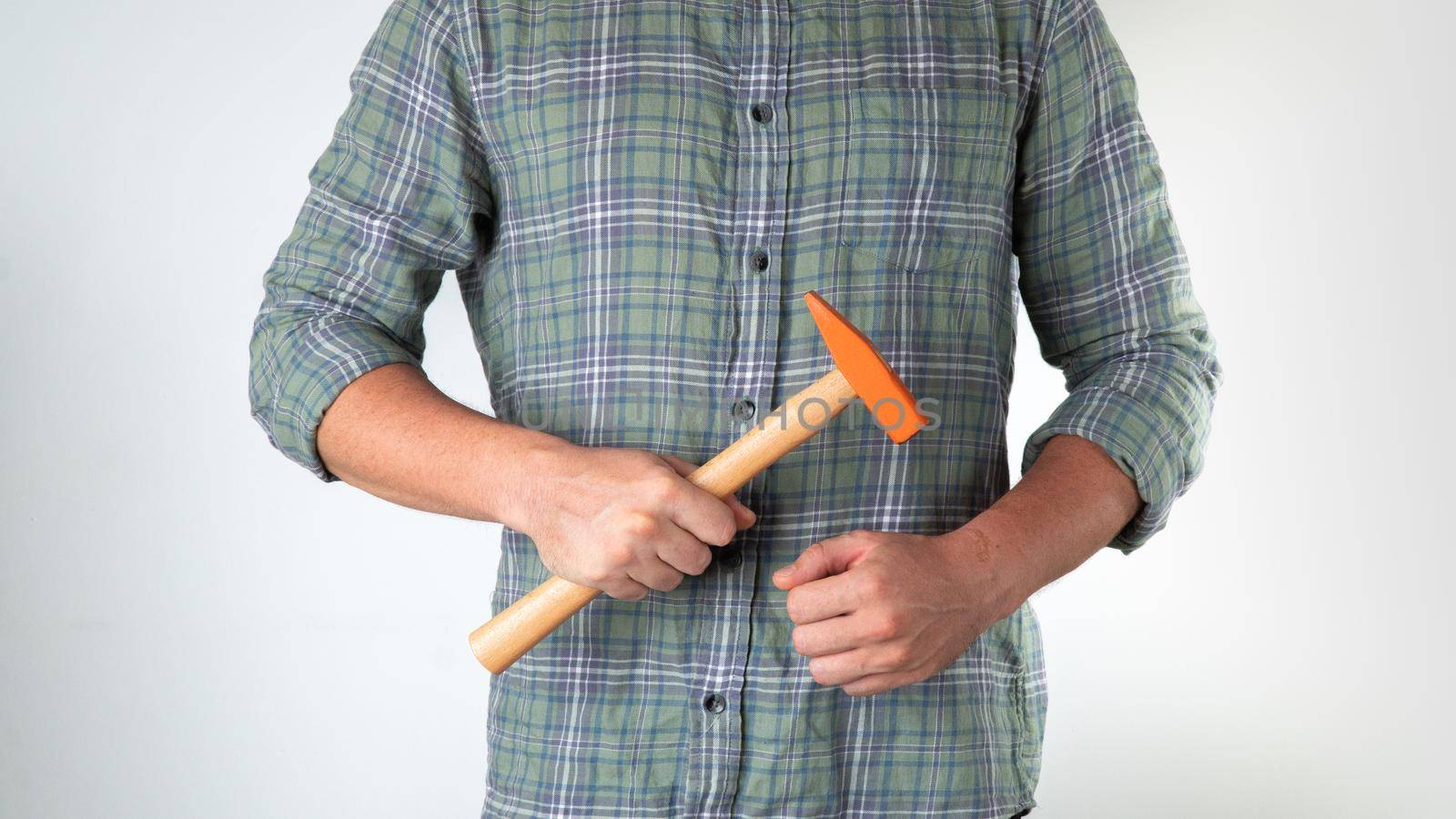 A man with a hammer in his hands on a white background. High quality photo