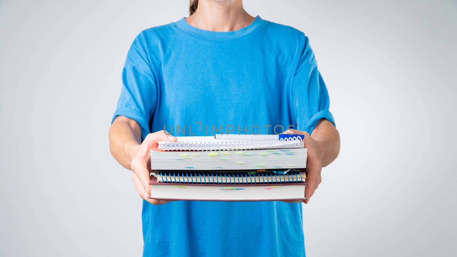 A female student with a stack of books and notebooks for classes by voktybre