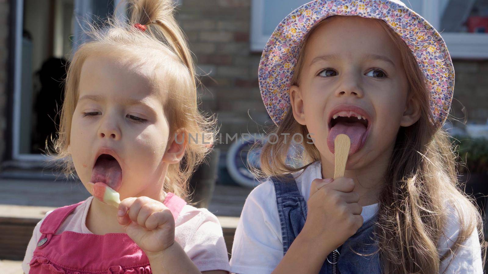 Three cute little Children enjoys delicious ice cream cone. Child eating watermelon popsicle. Kids Siblings snack sweets in Home Garden. Summer holiday Hot weather Sunny Day. Childhood, Food Candy by mytrykau