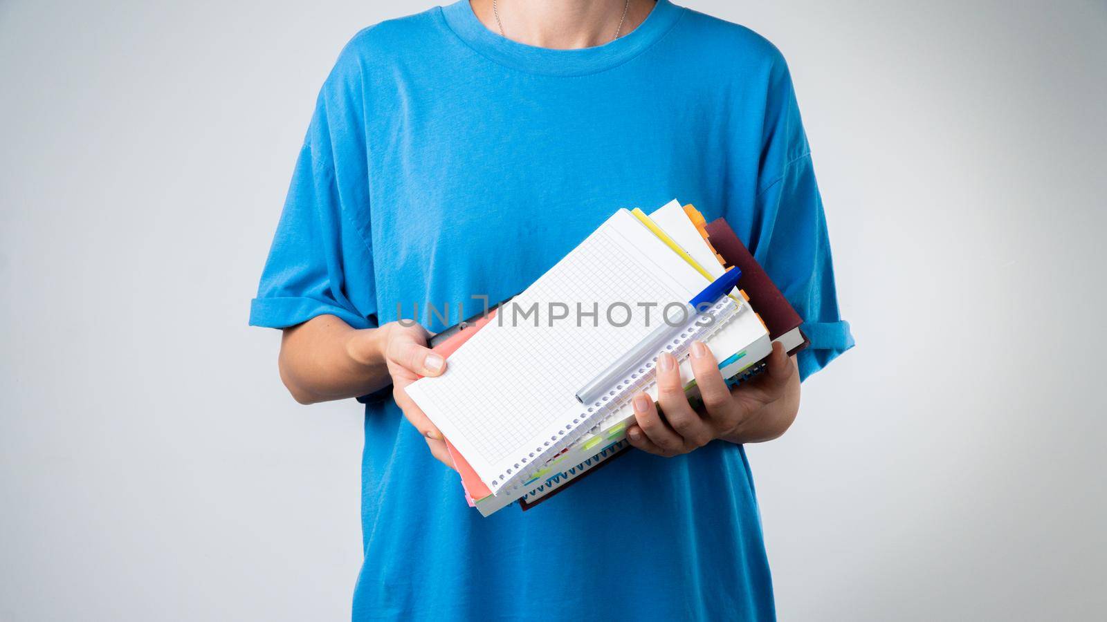 Female student with books and notebooks in her hands - training. High quality photo