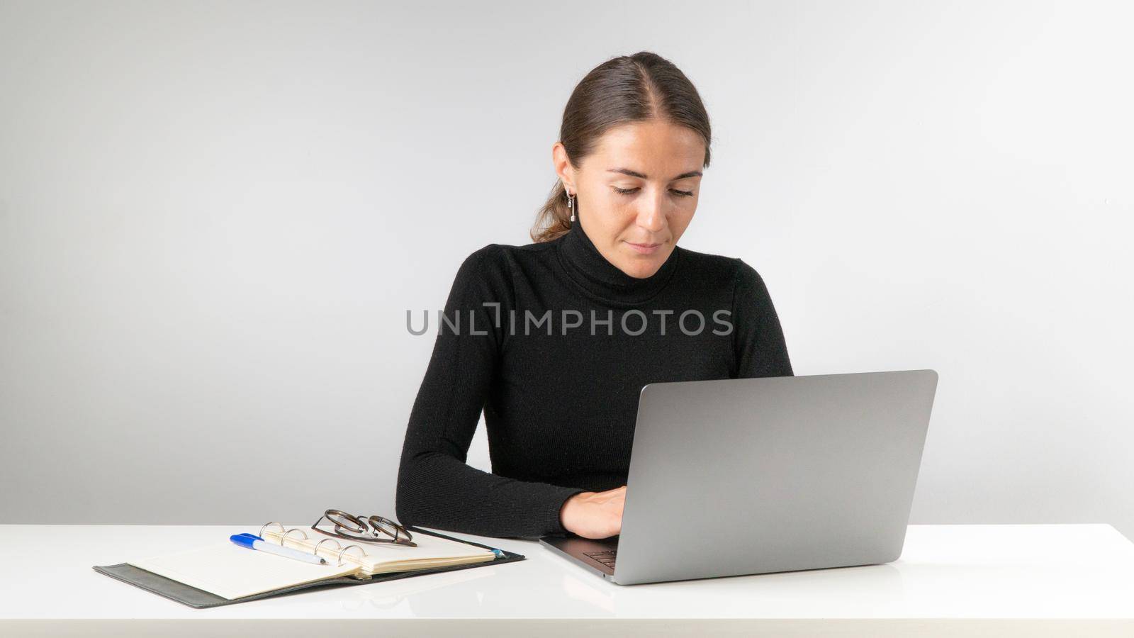 A female office worker works at a laptop. High quality photo