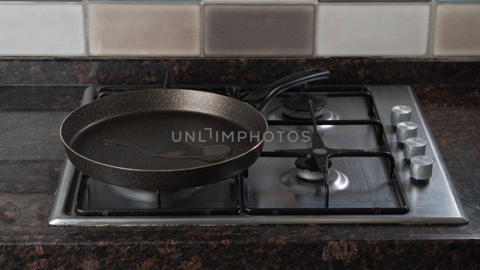 A frying pan with poured vegetable oil is on a gas stove by voktybre