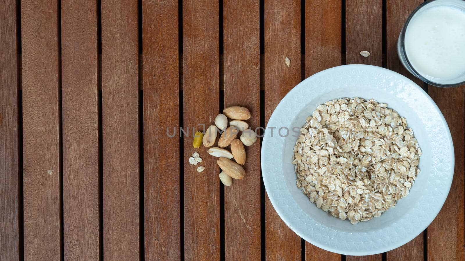 oatmeal, milk and nuts for breakfast on a wooden background, space for inscription. High quality photo