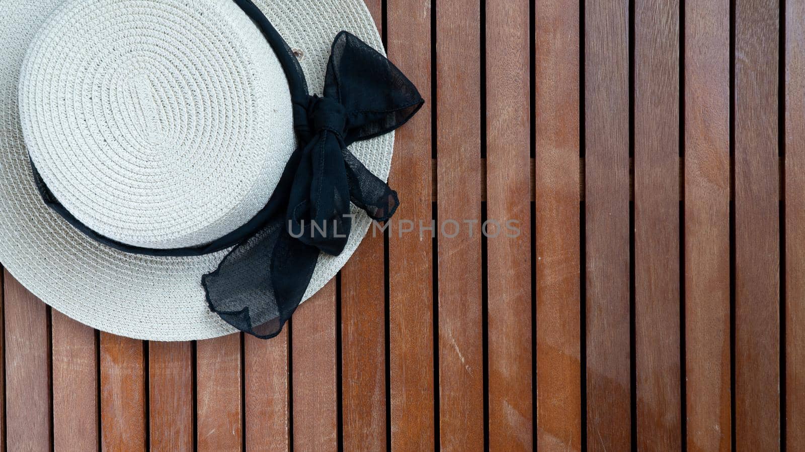 Women's light straw hat on a wooden background place for inscription. High quality photo