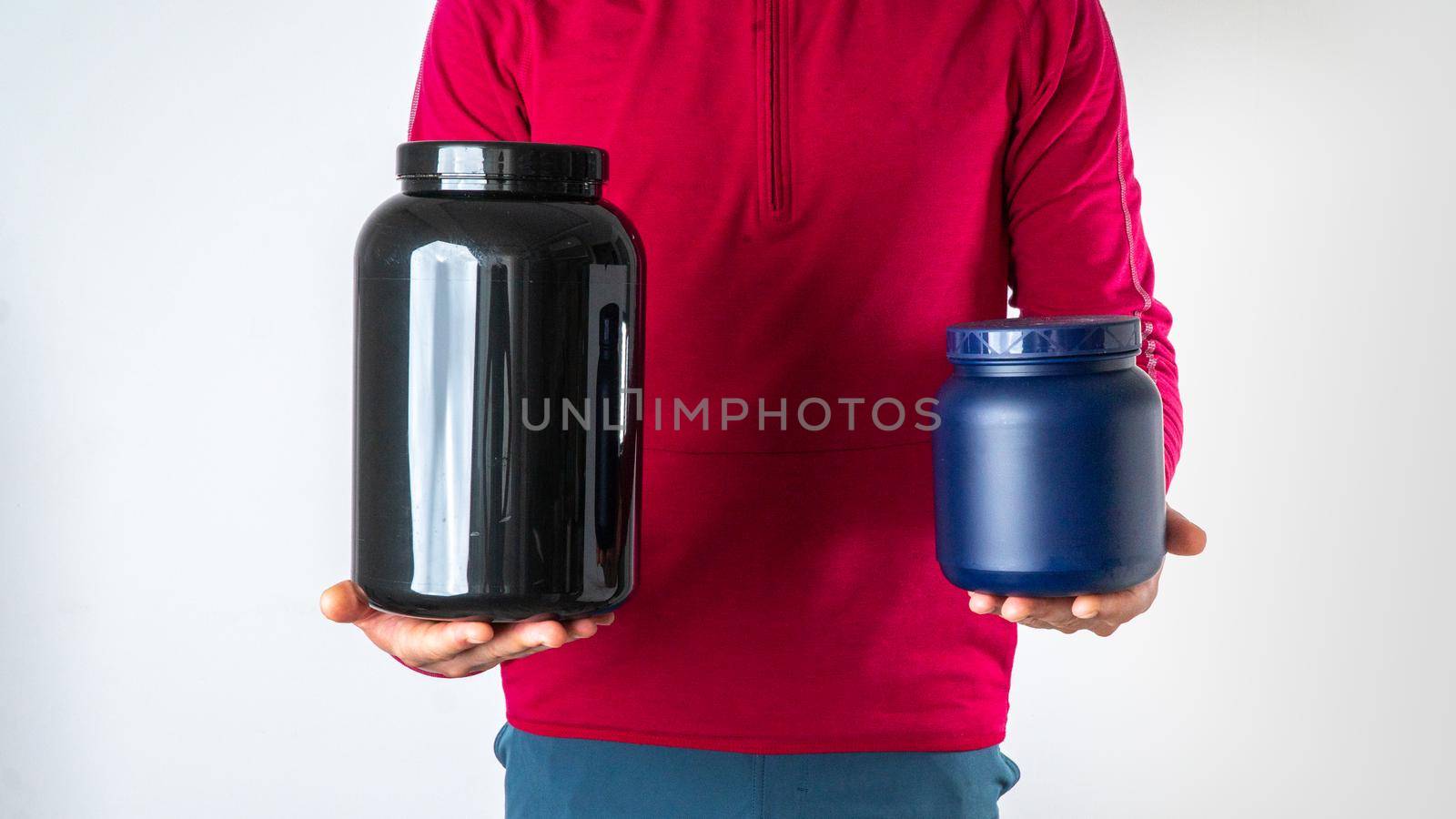Sports man with sports nutrition, cans with sports supplements in his hands. High quality photo