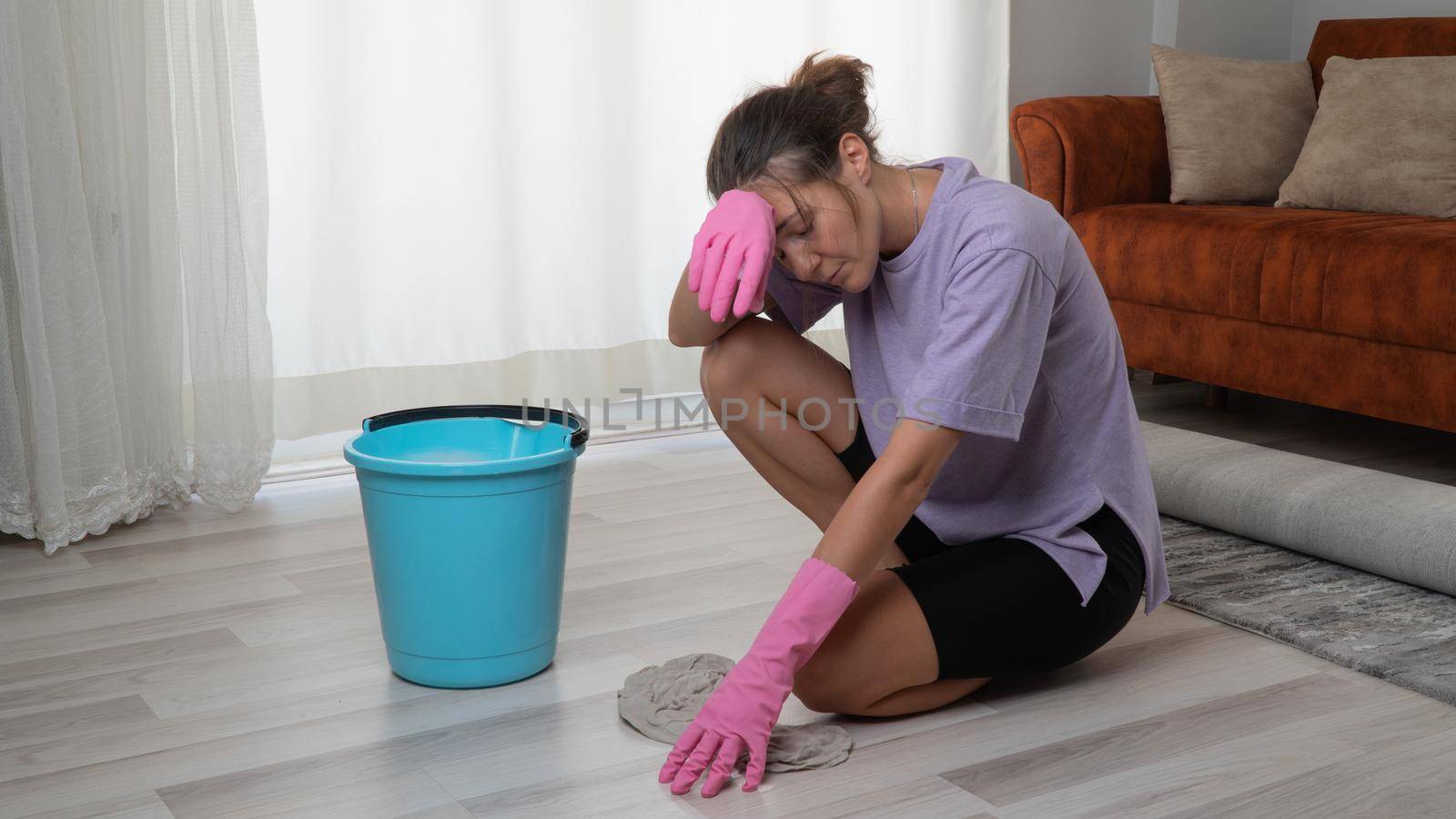 A tired woman washes the floor with a rag on her lap by voktybre