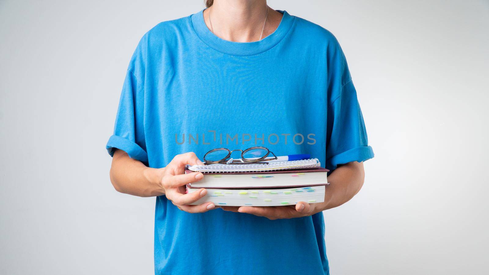 Glasses, notebooks, books in the hands of the student on a white background - training in courses and lessons. High quality photo