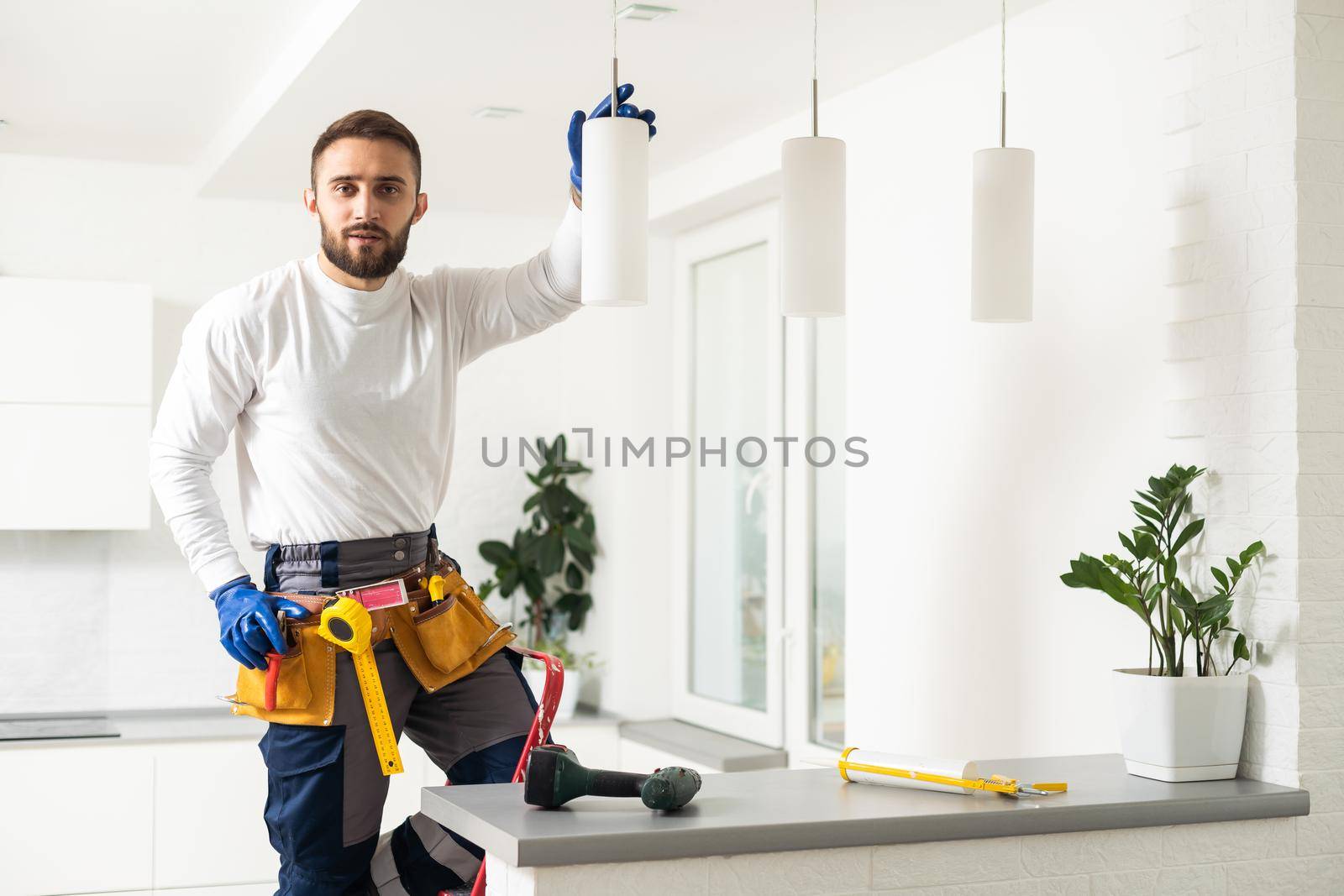 Electrician worker installation electric lamps light inside apartment. Construction decoration concept