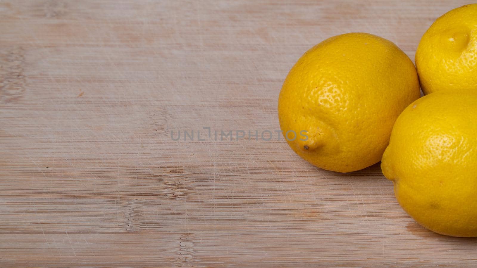 Yellow lemons on a wooden background close-up by voktybre
