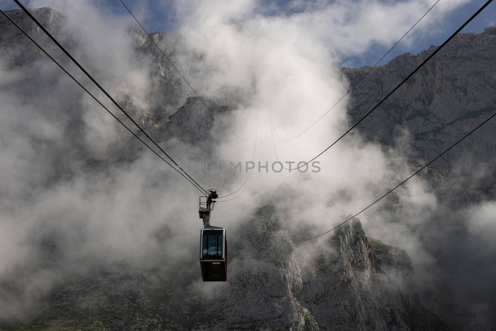 Foggy landscape showing a cable car and a rocky mountain in Fuente De in Picos de Europa in Spain