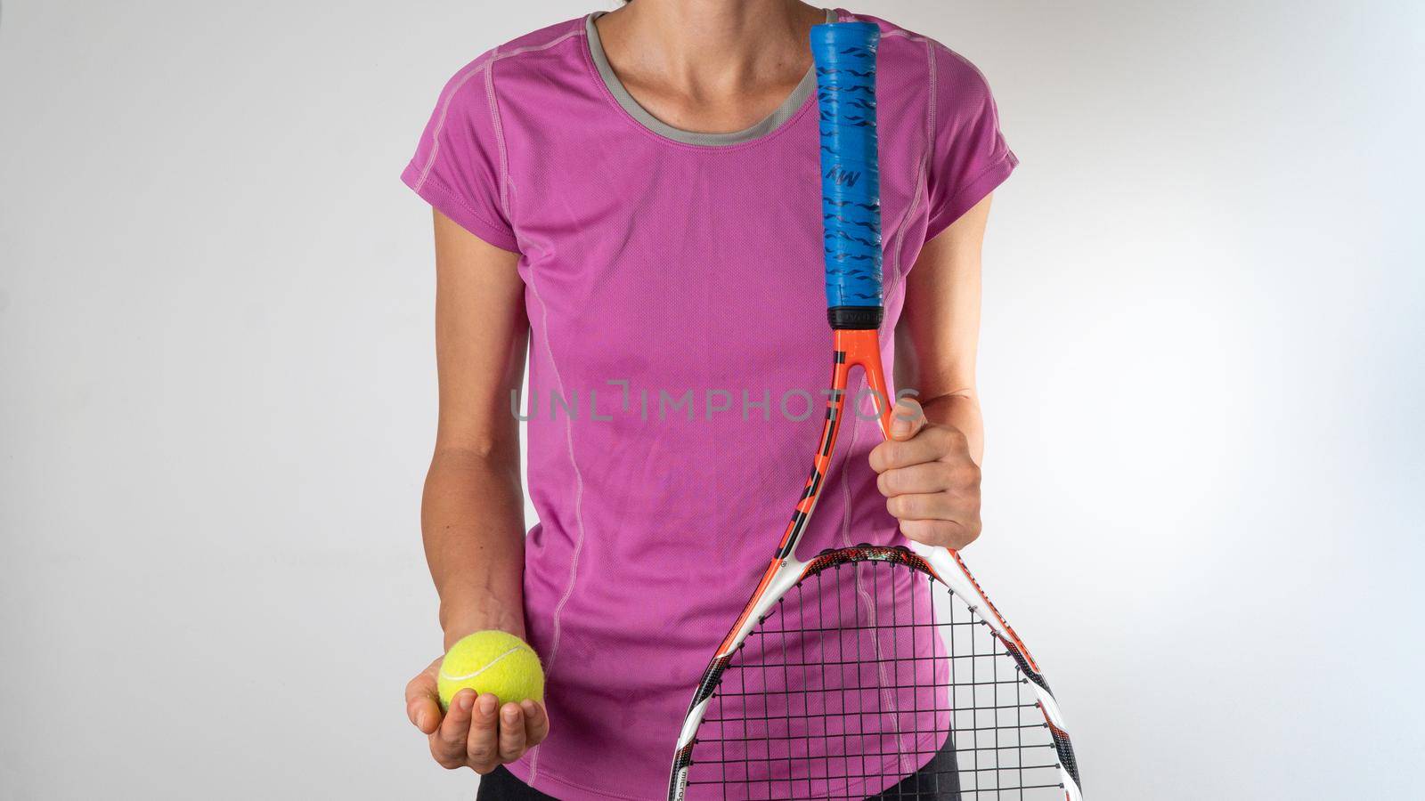 A woman holds a racket and a tennis ball. High quality photo