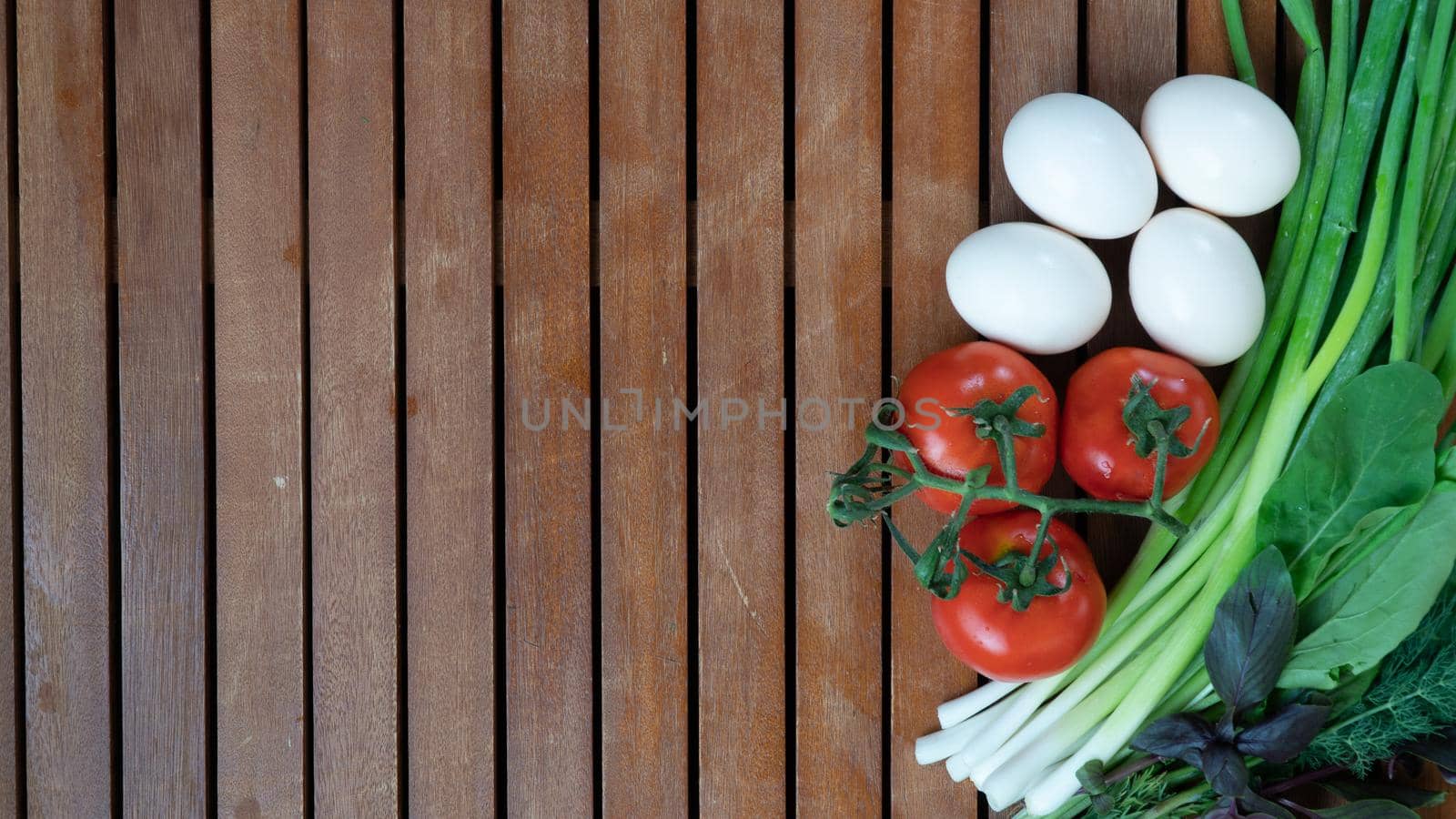 Greens, vegetables and eggs on a wooden background by voktybre