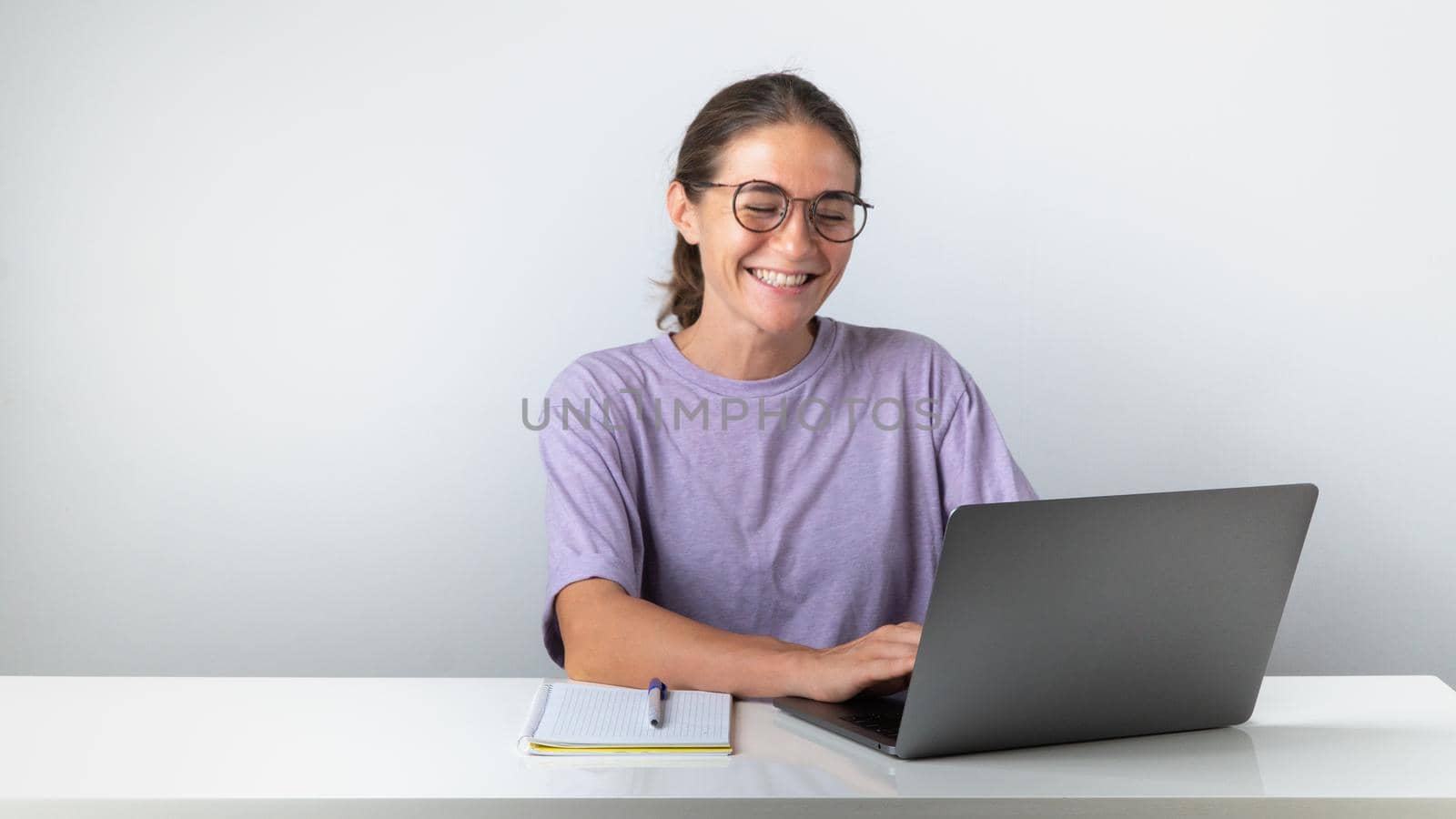 The girl at the laptop smiles, pleasant communication, good news by voktybre