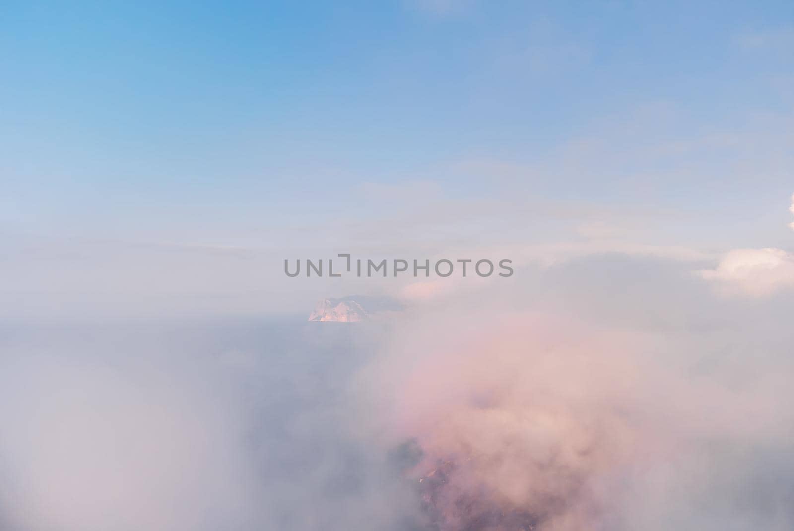 Aerial view. The drone flies over foggy and fluffy clouds. Blue sky sun and sea fog. Abstract aerial nature summer ocean sunset sea and sky background. Vacation, travel and holiday concept by panophotograph