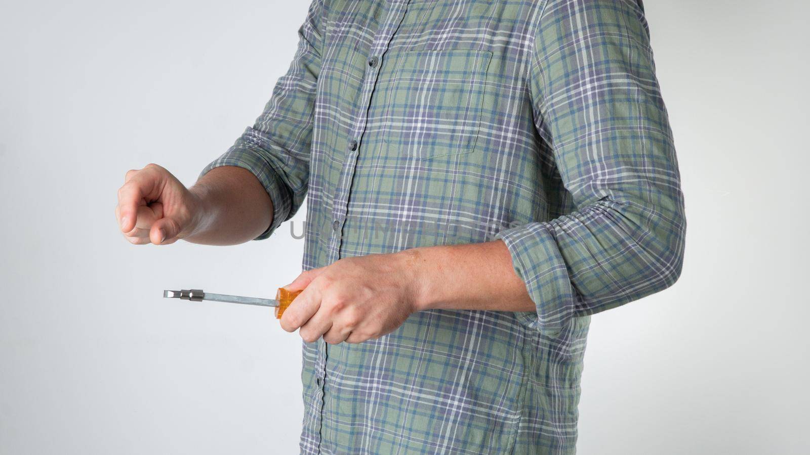 A man holds a screwdriver in his hand on a white background. High quality photo