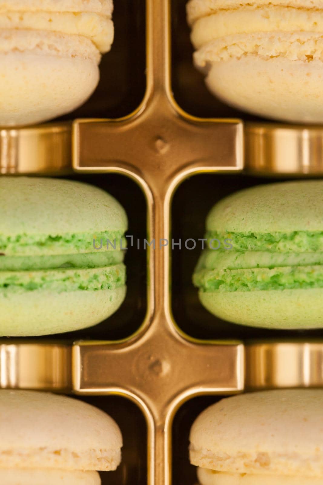 Close up colorful french macaroons in a golden box. Sweet dessert