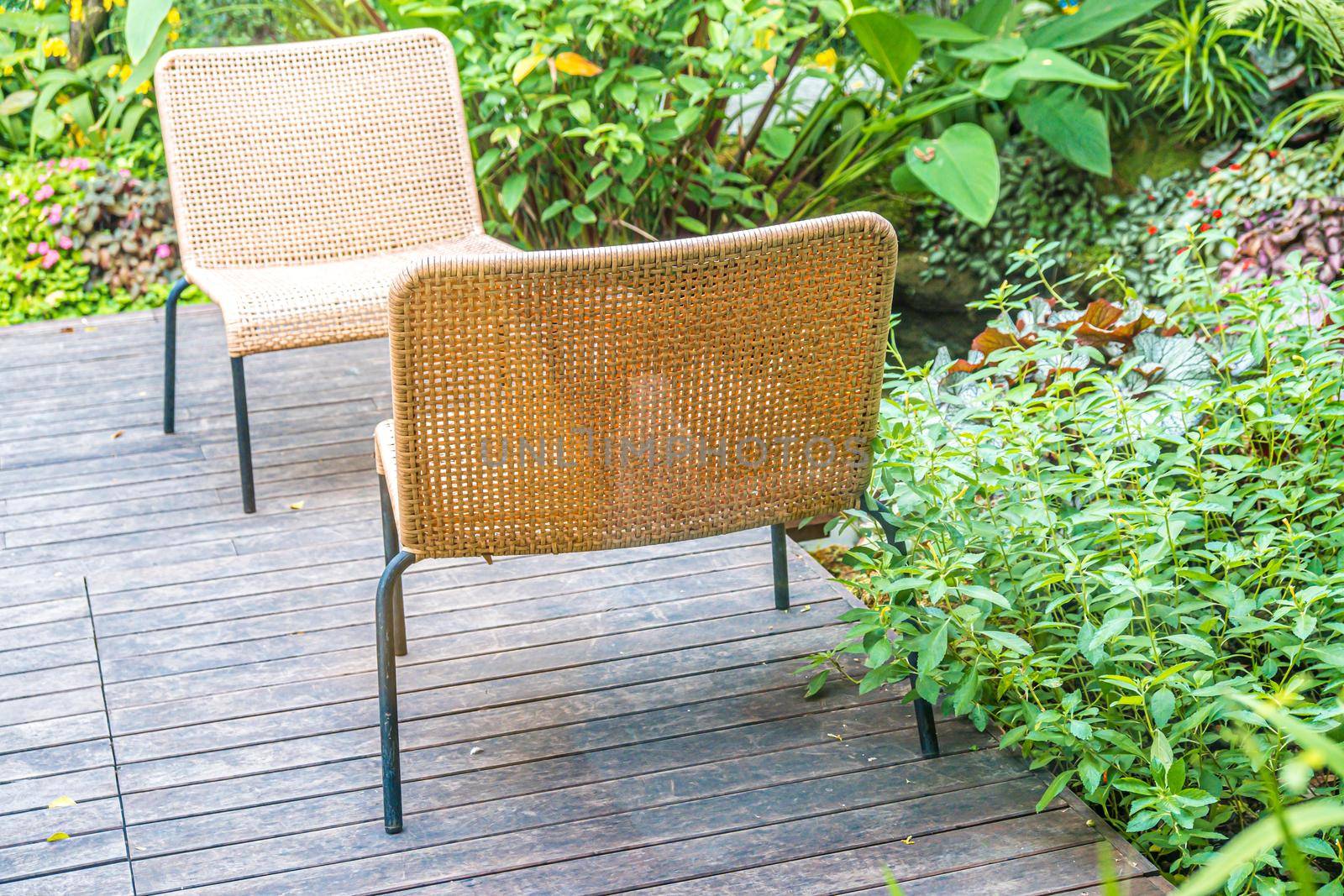 outdoor cream color woven chair decoration put on the wooden deck terrace in garden.