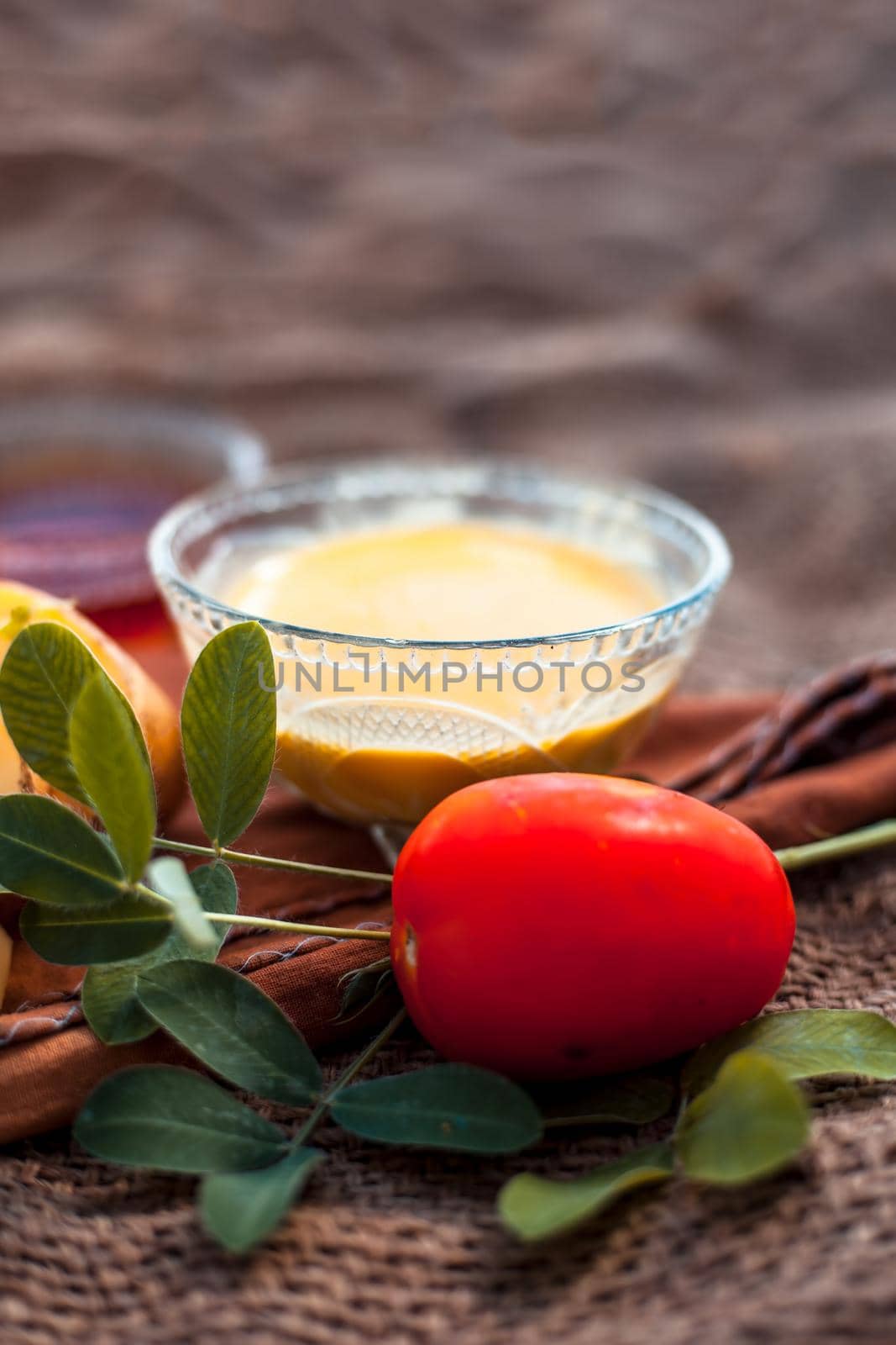 Potato juice's face pack for acne on jute bag's surface consisting of potato juice and tomato juice well mixed together with the help of honey.Vertical shot.