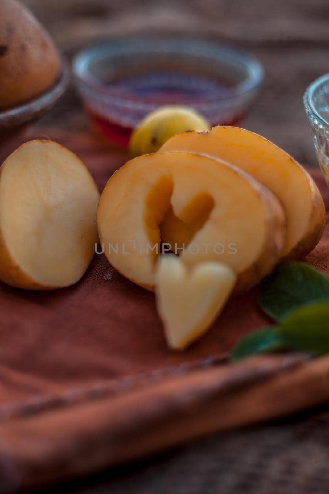 Glowing face mask of potato juice in a glass bowl on brown colored surface along with some lemon juice,potato juice and honey.Horizontal shot. by mirzamlk