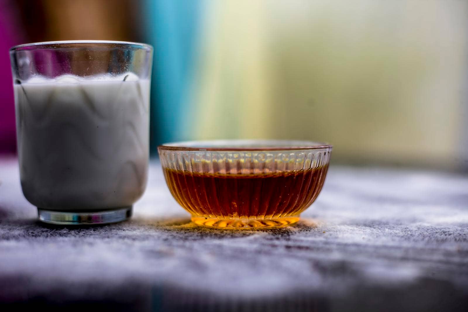 Face mask for flawless skin on wooden surface consisting of rice flour,corn flour,honey,milk, in a glass bowl and entire raw ingredients present on the surface.