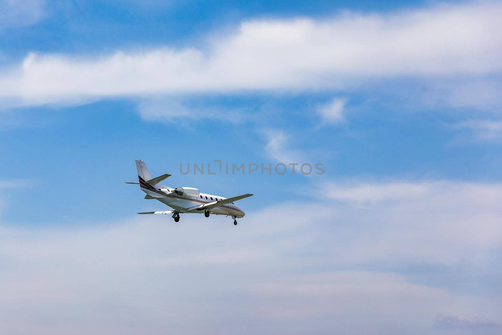 Landing airplane. Landscape with passenger airplane is flying in the blue sky with clouds. Passenger airliner. Business trip. Commercial aircraft. Passenger airplane flying and getting ready to land.