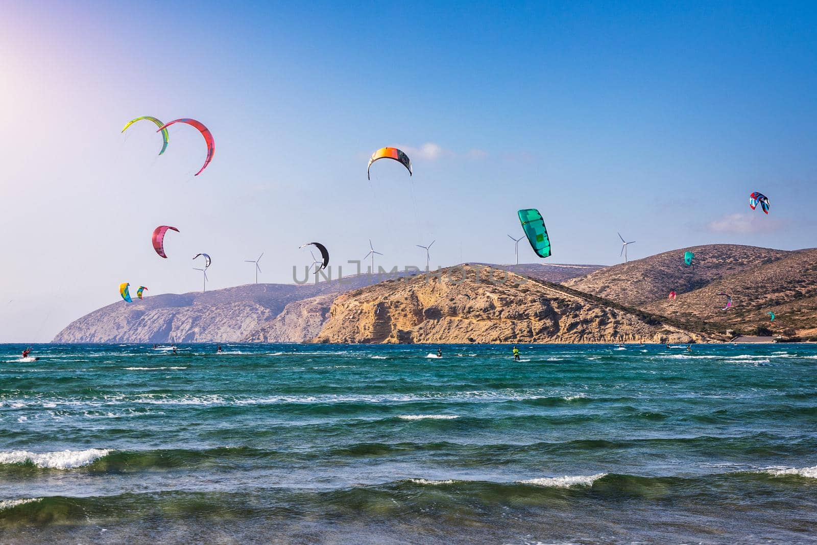 Surfers in Prasonisi Beach in Rhodes island, Greece. Kiteboarder kitesurfer athlete performing kitesurfing kiteboarding tricks. Prasonisi Beach is popular location for surfing. Greece