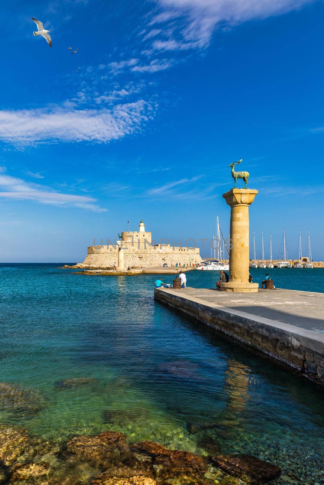 Mandraki port with deers statue, where The Colossus was standing and fort of St. Nicholas. Rhodes, Greece. Hirschkuh statue in the place of the Colossus of Rhodes, Rhodes, Greece