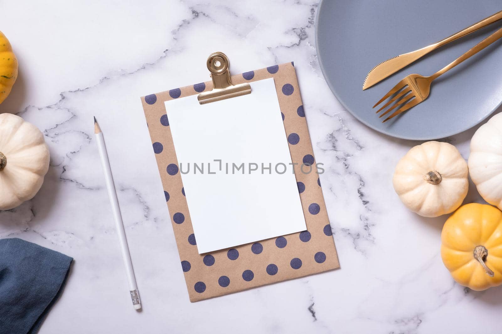 Autumn flat lay with blank tablet and decorative pumpkins on marble background top view.