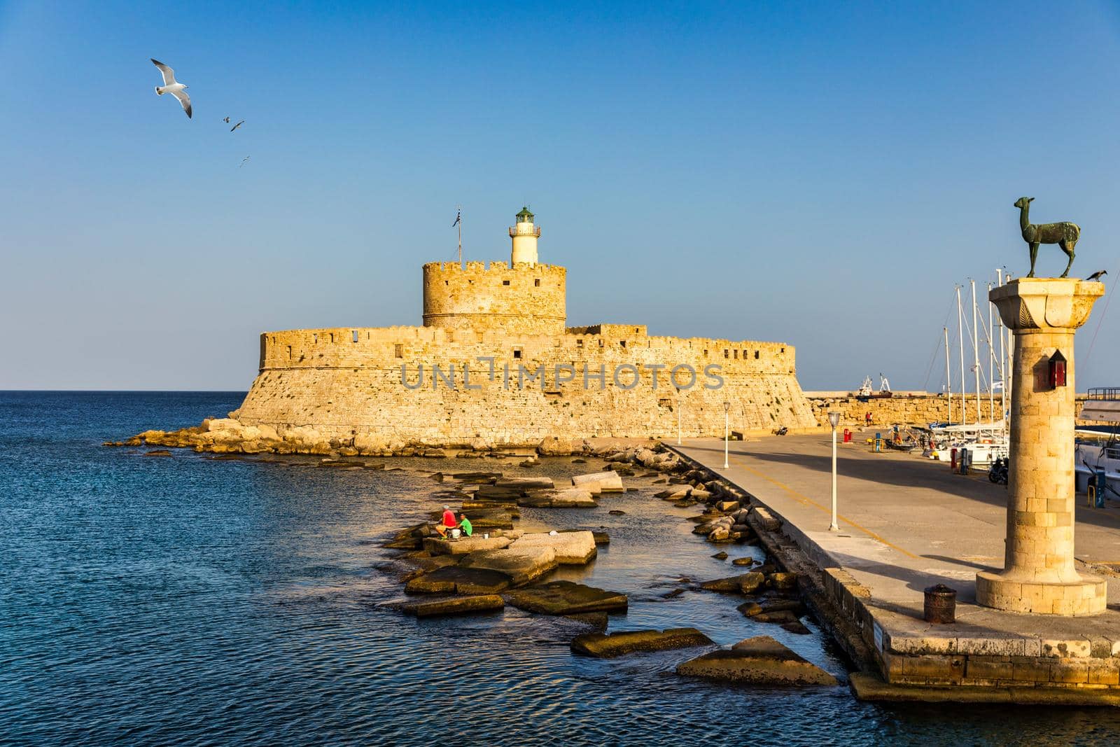 Mandraki port with deers statue, where The Colossus was standing and fort of St. Nicholas. Rhodes, Greece. Hirschkuh statue in the place of the Colossus of Rhodes, Rhodes, Greece