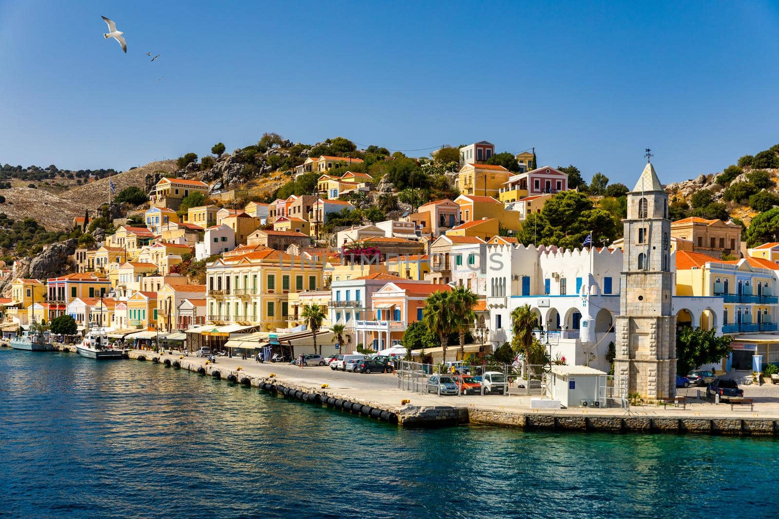 View of the beautiful greek island of Symi (Simi) with colourful houses and small boats. Greece, Symi island, view of the town of Symi (near Rhodes), Dodecanese.