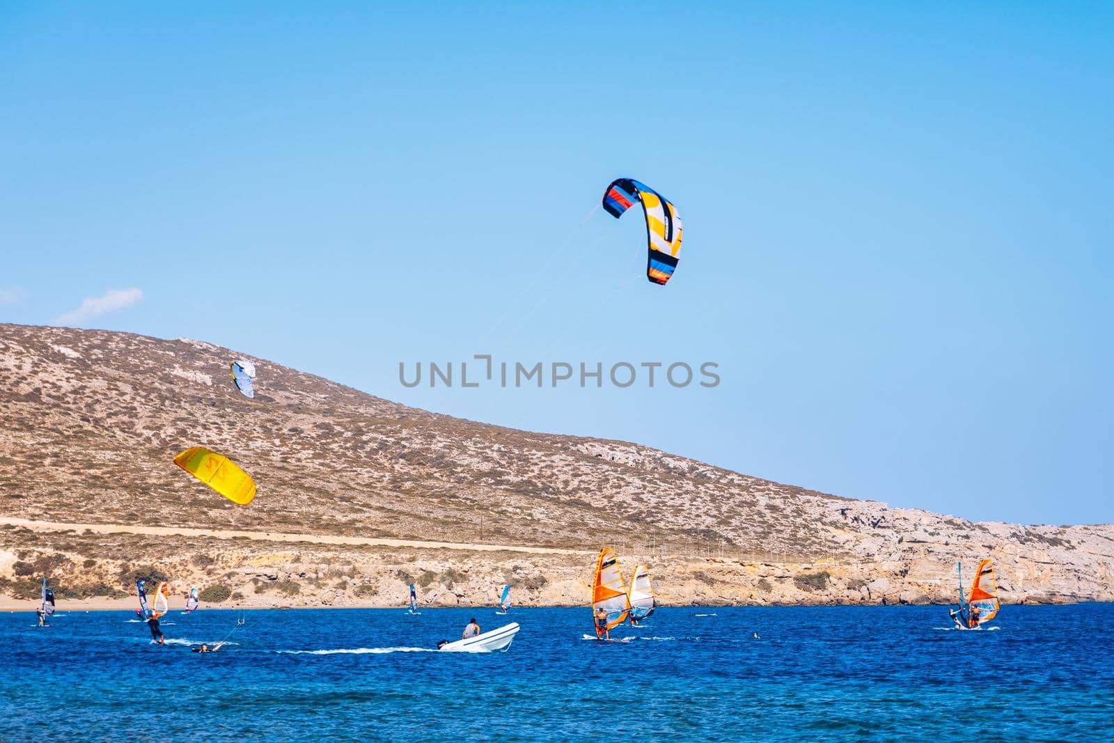 Surfers in Prasonisi Beach in Rhodes island, Greece. Kiteboarder kitesurfer athlete performing kitesurfing kiteboarding tricks. Prasonisi Beach is popular location for surfing. Greece