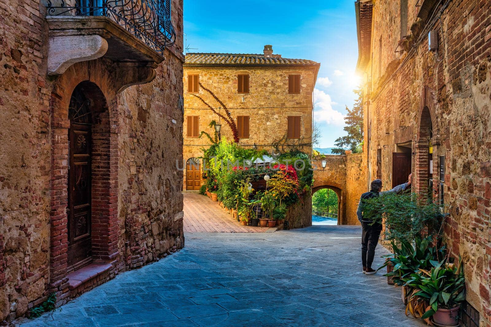 Cozy street decorated with colorful flowers, Pienza, Tuscany, Italy, Europe. Narrow street in the charming town of Pienza in Tuscany. Beautiful streets of the small and historic village Pienza, Italy