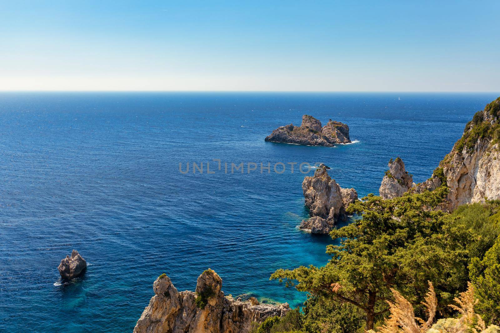 Picturesque seaside of Paleokastritsa, Corfu, Greece. Beautiful bay in Paleokastritsa in Corfu island, Greece. Panoramic view of Palaiokastritsa, boats and beach Corfu, Greece