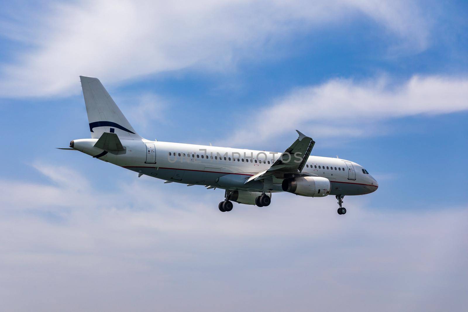 Landing airplane. Landscape with passenger airplane is flying in the blue sky with clouds. Passenger airliner. Business trip. Commercial aircraft. Passenger airplane flying and getting ready to land.