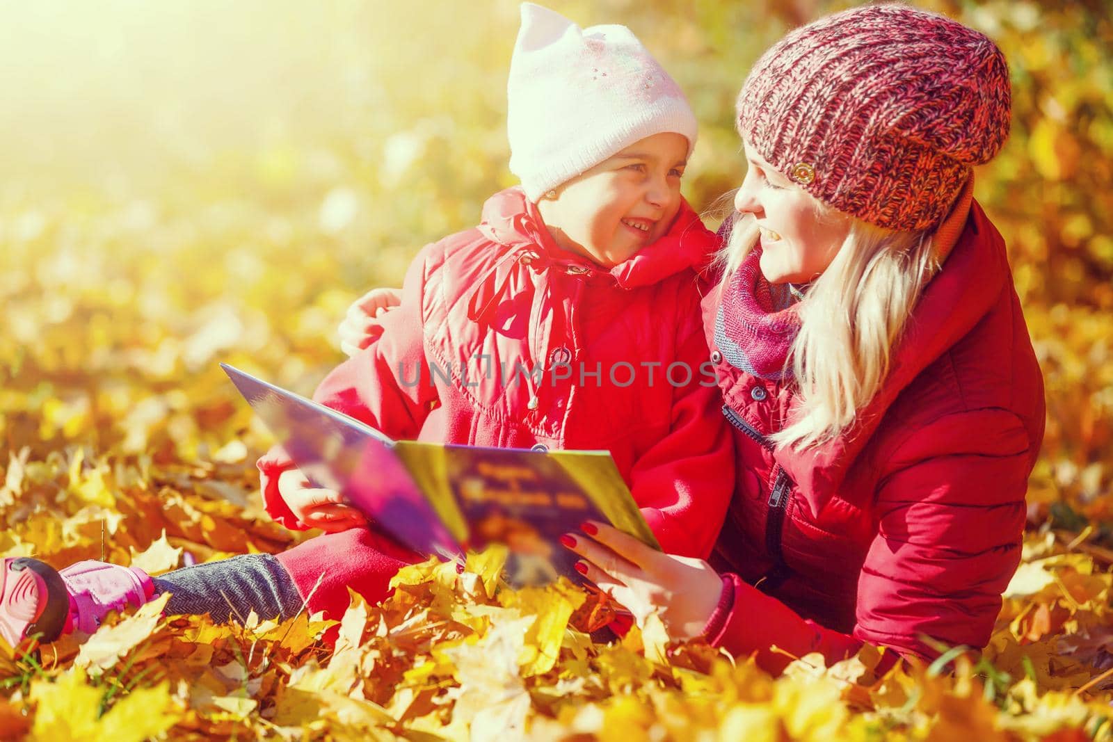 Little girl and her mother playing in the autumn park