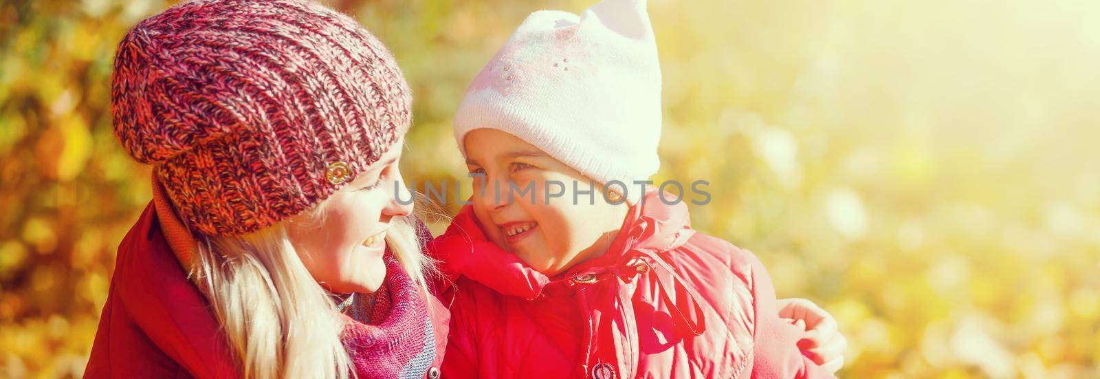 Little girl and her mother playing in the autumn park