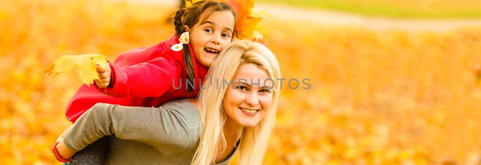 Cute family walking in a autumn park. Mother with little daughter by Andelov13