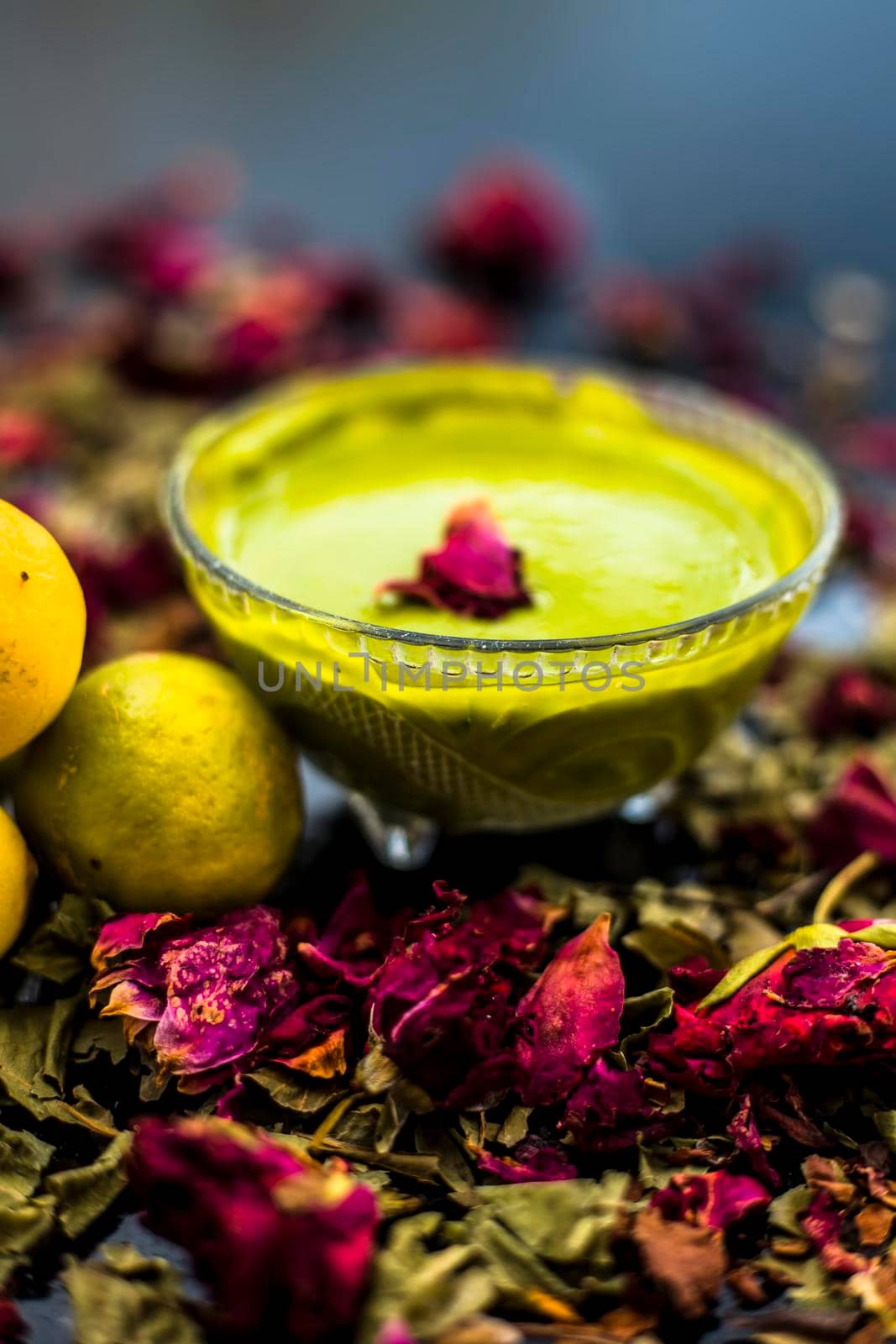 Neem or Indian Lilac face mask on the black wooden surface for oily skin consisting of neem leaves paste and lemon juice well mixed with rose water. by mirzamlk