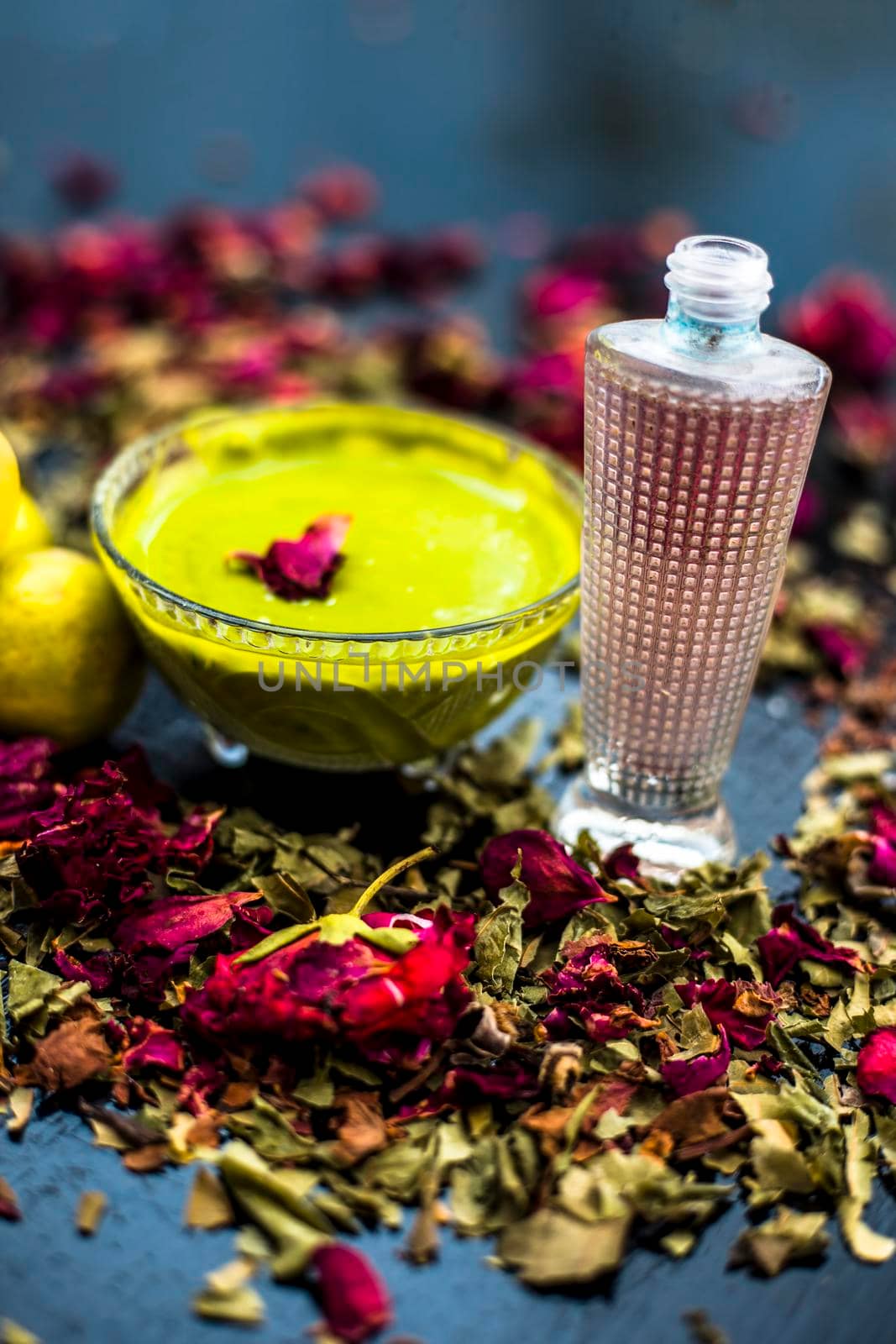 Neem or Indian Lilac face mask on the black wooden surface for oily skin consisting of neem leaves paste and lemon juice well mixed with rose water. by mirzamlk