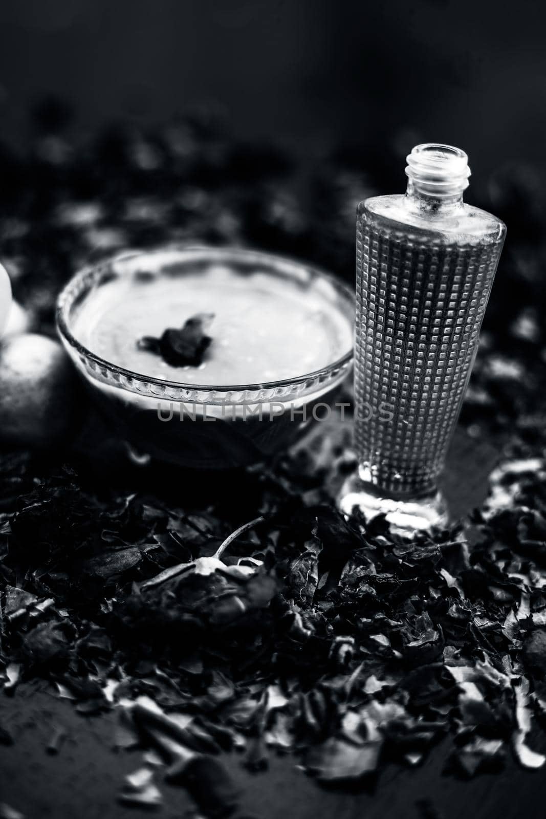 Neem or Indian Lilac face mask on the black wooden surface for oily skin consisting of neem leaves paste and lemon juice well mixed with rose water.