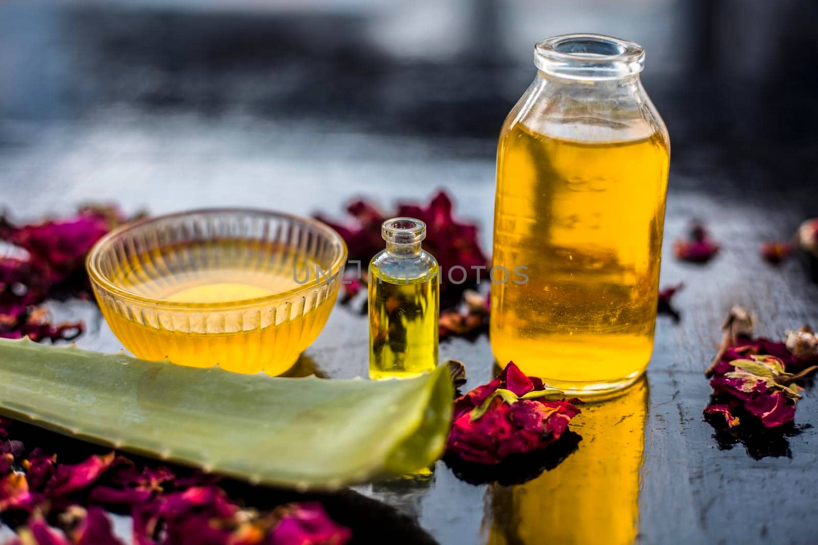 The trio pack of herbs and ingredients to fight dandruff on the wooden surface well mixed in a glass bowl which are castor oil, tea tree oil, and some aloe vera gel. Also used to treat itchiness.;