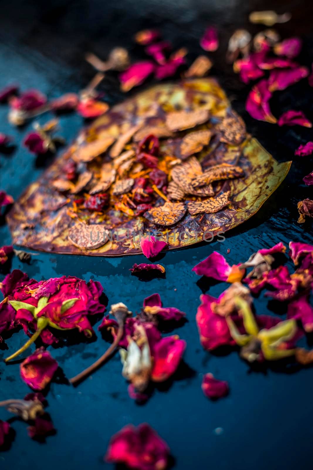 Close up of Famous Indian traditional masala pan or meetha pan on black surface with some rose water consisting of coated sauf,supari,sweeteners and some coconut powder.