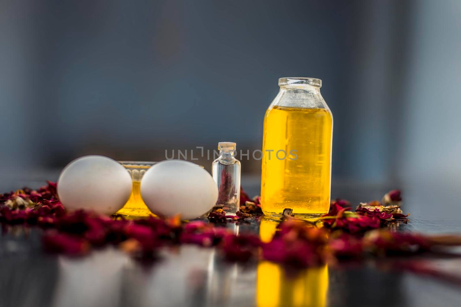 Trio pack of herbs and ingredients to fight dandruff on the wooden surface well mixed in a glass bowl which are castor oil, coconut oil, and egg. Also used to treat itchiness and to deep condition.