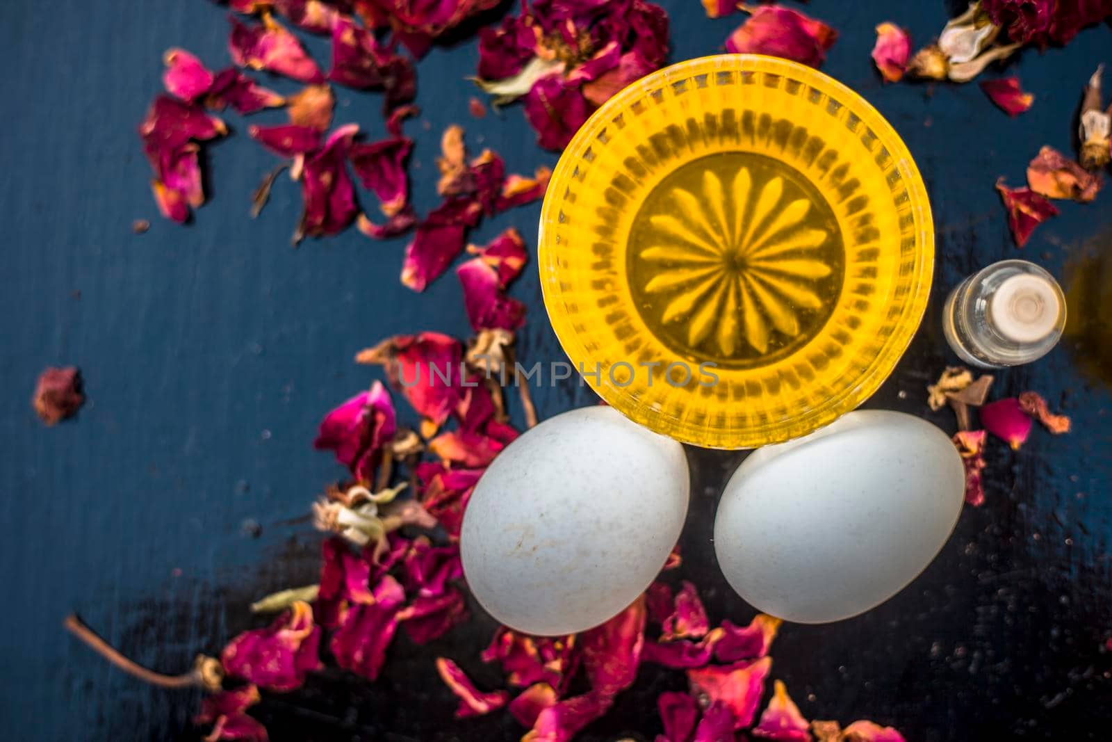 Trio pack of herbs and ingredients to fight dandruff on the wooden surface well mixed in a glass bowl which are castor oil, coconut oil, and egg. Also used to treat itchiness and to deep condition.