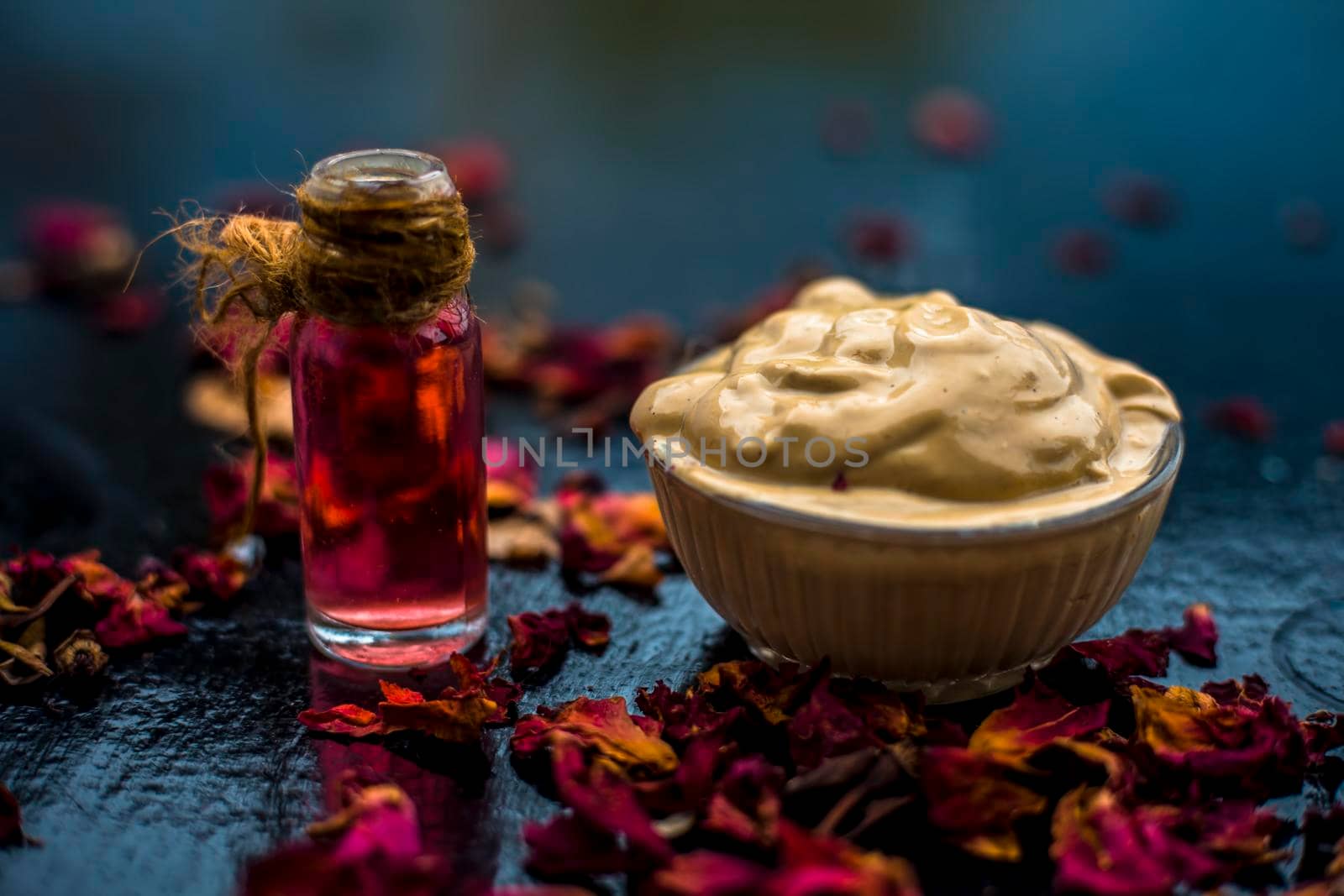 Ubtan/face mask/face pack of Multani mitti or fuller's earth on wooden surface in a glass bowl consisting of Multani mitti and rose water for the remedy or treatment of oily skin.On wooden surface.