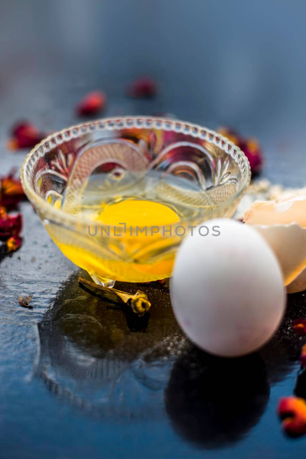 Egg and besan or chickpea flour or gram flour on wooden surface in a glass bowl along with raw egg and flour on the surface.For the treatment of lines and wrinkles. by mirzamlk