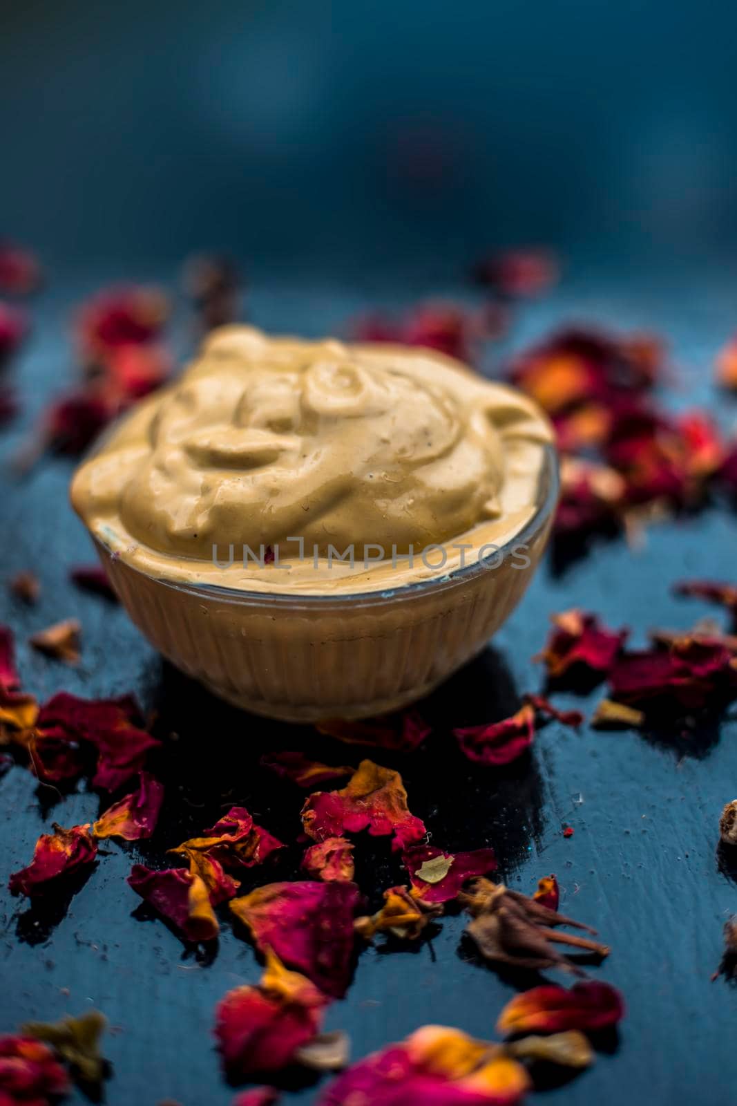 Ubtan/face mask/face pack of Multani mitti or fuller's earth on wooden surface in a glass bowl consisting of Multani mitti and rose water for the remedy or treatment of oily skin.On wooden surface. by mirzamlk