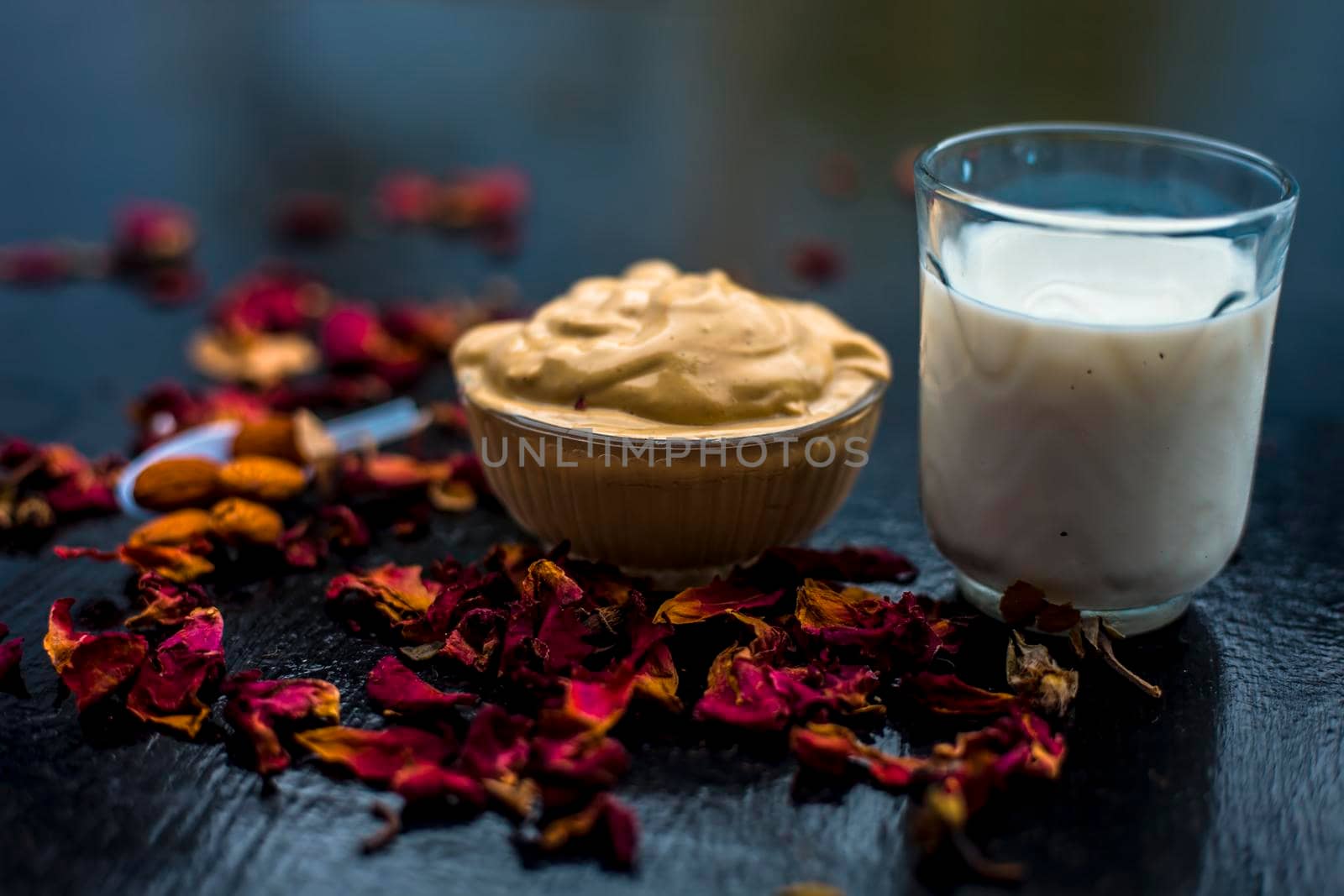 Multani mitti or fuller's earth or mulpani mitti face mask on wooden surface in glass bowl consisting of milk, almonds, and bentonite clay.For the treatment of softer skin.