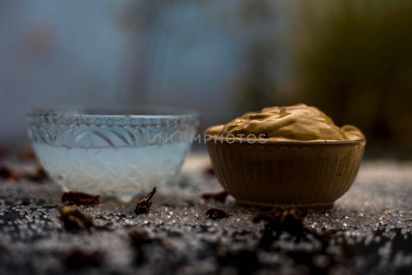 Ubtan/face mask/face pack of Multani mitti or fuller's earth on wooden surface in a glass bowl consisting of Multani mitti and coconut oil for the remedy or treatment of suntan.On the wooden surface.